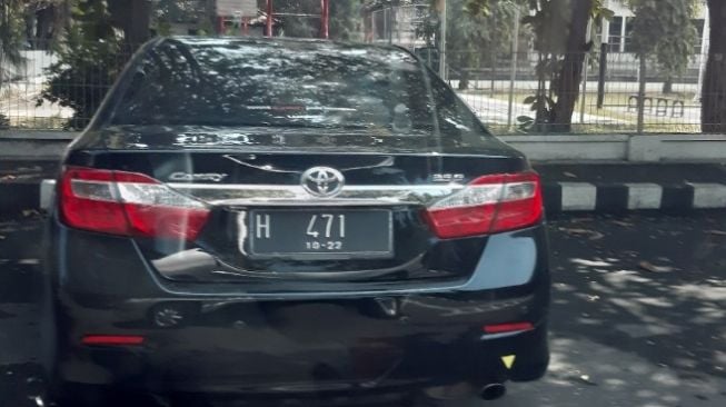 Toyota Camry yang terparkir menggunakan pelat nomor sama dengan Kijang Innova (Facebook)