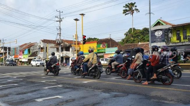 Pengendara motor dengan rapi berhenti di marka jalan yang mirip di lintasan MotoGP di simpang empat Paseban, Bantul, Jumat (24/7/2020). - (SuaraJogja.id/Hiskia Andika)