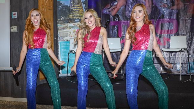 Personil baru grup dangdut Trio Macan yaitu Nanda (kiri), Elok (tengah) dan Vira (kanan) saat beraksi membawakan lagu 'Iwak Peyek' di Kawasan Darmawangsa, Jakarta Selatan, Jumat (24/7). [Suara.com/Alfian Winanto]