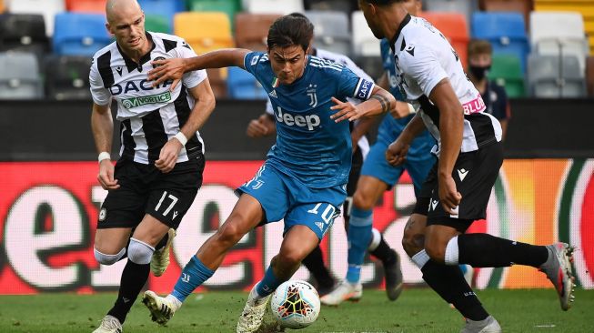 Pemain depan Juventus Paulo Dybala (C) bersaing untuk mendapatkan bola dengan pemain belakang Udinese Bram Nuytinck (kiri) dan pemain belakang Udinese William Troost-Ekong (kanan)  selama pertandingan sepak bola Serie A Italia antara Udinese melawan  Juventus di Stadion Dacia Arena, Udinese, Italia, Jumat (24/7) dini hari WIB.[MARCO BERTORELLO / AFP]