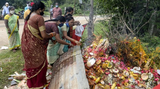 Umat Hindu memberikan persembahan kepada patung-patung ular pada kesempatan Nag Panchami untuk pemujaan tradisional dewa ular di Sri Manasa Devi dan kuil Nagadevata di Secunderabad, kota kembar Hyderabad, India, Sabtu (25/7/2020). [NOAH SEELAM / AFP]
