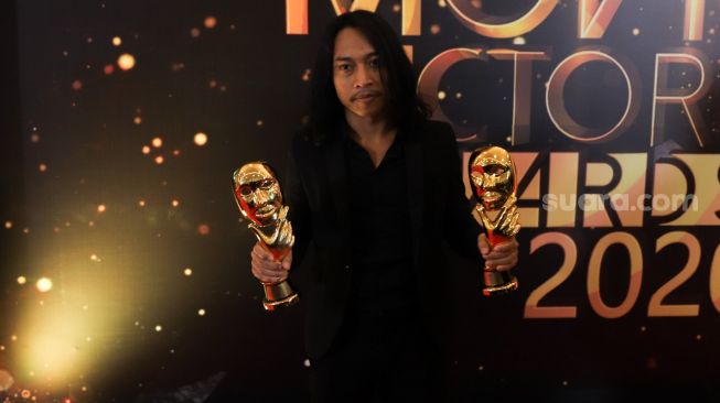 Aktor Muhammad Khan meraih penghargaan Pemeran Pendatang Baru Terbaik karena perannya di film 'Kucumbu Tubuh Indahku' dalam gelaran Indonesian Movies Actors Awards 2020 (IMAA) di Jakarta, Sabtu (25/7). [Suara.com/Alfian winanto]