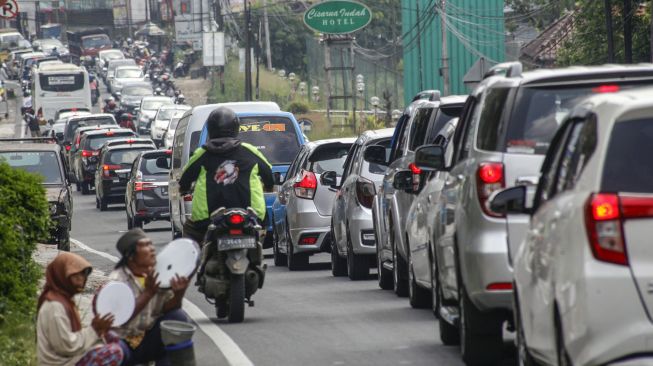 Kendaraan menumpuk di Jalan Raya Puncak, Kabupaten Bogor, Jawa Barat, Minggu (26/7/2020). [ANTARA FOTO/Yulius Satria Wijaya]