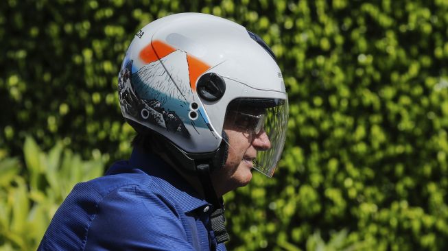 Presiden Brasil Jair Bolsonaro saat menaiki sepeda motornya di Brasilia, Sabtu (25/7/2020). [Sergio Lima / AFP]