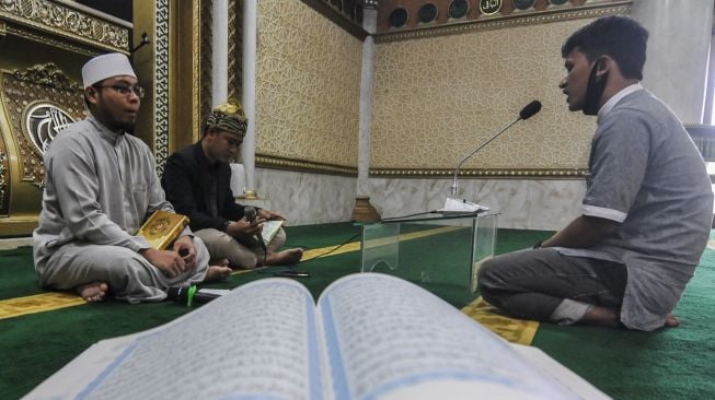 Peserta mengikuti program kambing gratis untuk Hafiz (Penghafal) Al Quran di Masjid Raya Muhammad Ramadhan, Bekasi, Jawa Barat, Minggu (26/7/2020). [ANTARA FOTO/ Fakhri Hermansyah]