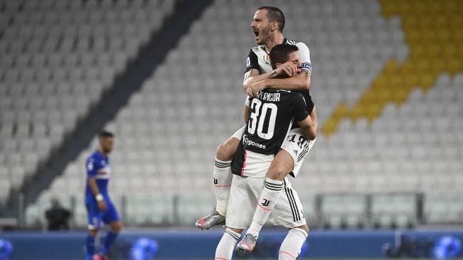 Bek Juventus, Leonardo Bonucci merayakan gelar Serie A (scudetto) dengan gelandang Juventus asal Uruguay Rodrigo Bentancur setelah pertandingan sepak bola Serie A Italia antara Juventus dan Sampdoria di Stadion Allianz di Turin, Minggu (26/7/2020). [MARCO BERTORELLO / AFP]