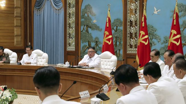 Pemimpin Korea Utara, Kim Jong-un memimpin pertemuan darurat dalam foto yang dirilis KCNA di Pyongyang, Korea Utara, pada Sabtu (25/7/2020). [STR / KCNA VIA KNS / AFP]