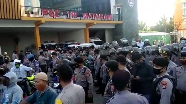 Sejumlah petugas kepolisian mengamankan massa dari Desa Telagawaru, Kabupaten Lombok Barat, Nusa Tenggara Barat, yang menjemput paksa jenazah laki-laki yang positif COVID-19 berinisial M (34), di Rumah Sakit Umum Daerah (RSUD) Kota Mataram, Senin pagi (27/7/2020). ANTARA/HO-Aspri