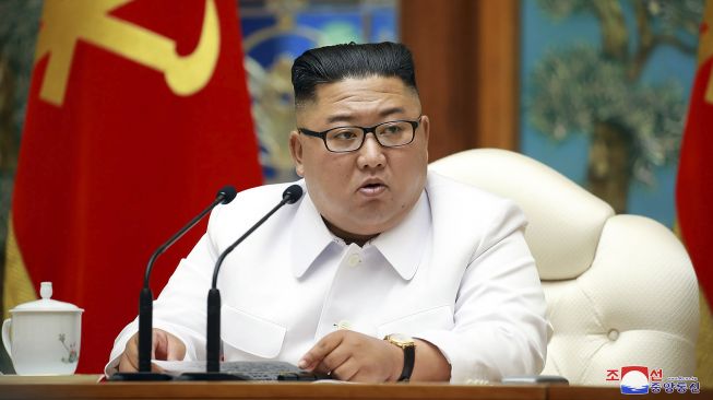 Pemimpin Korea Utara, Kim Jong-un memimpin pertemuan darurat dalam foto yang dirilis KCNA di Pyongyang, Korea Utara, pada Sabtu (25/2020). [STR / KCNA VIA KNS / AFP]