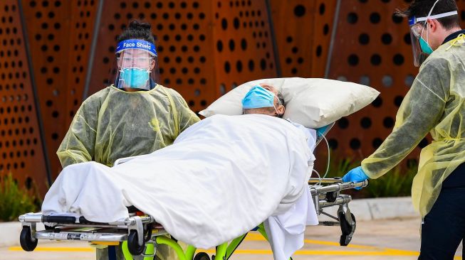 Petugas ambulan memindahkan seorang penduduk dari fasilitas perawatan lansia Epping Gardens di pinggiran kota Melbourne, Australia,  Selasa (28/7/2020).  [William WEST / AFP]