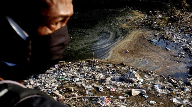 Warga melihat aliran sungai Cileungsi yang tercemar limbah di Bojong Kulur, Gunung Putri, Kabupaten Bogor, Jawa Barat, Senin (27/7/2020). [ANTARA FOTO/Yulius Satria Wijaya]