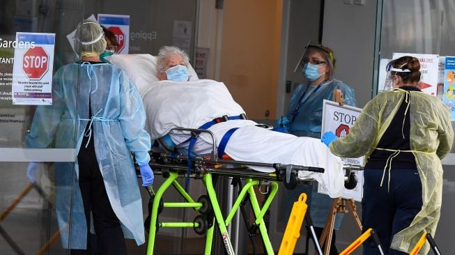 Petugas ambulan memindahkan seorang penduduk dari fasilitas perawatan lansia Epping Gardens di pinggiran kota Melbourne, Australia,  Selasa (28/7/2020).  [William WEST / AFP]