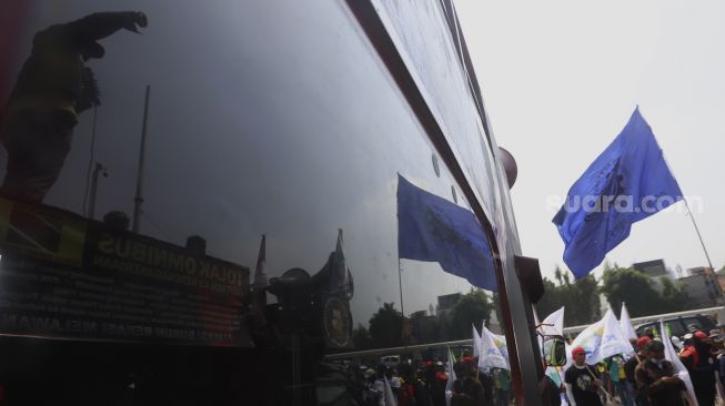 Refleksi massa buruh yang tergabung dalam Konfederasi Serikat Pekerja Indonesia ( KSPI) berorasi di atas mobil komando saat mengelar aksi unjuk rasa di depan Gedung DPR, Jakarta, Rabu (29/7/2020). [Suara.com/Angga Budhiyanto]