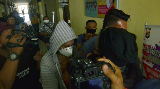 Personel kepolisian membawa artis berinisial VS (tengah) saat akan menjalani pemeriksaan di Polresta Bandar Lampung, Lampung, Rabu (29/7/2020).  [ANTARA FOTO/ Ardiansyah]