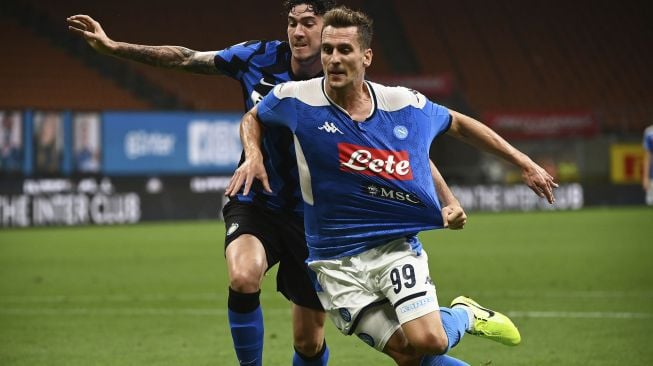 Bek Inter Milan Italia  bersaing dengan pemain depan Napoli Arkadiusz Milik selama pertandingan sepak bola Serie A Italia, Inter Milan melawan Napoli di Stadion Giuseppe Meazza, Milan, Italia, Rabu (29/7) dini hari WIB. [MARCO BERTORELLO / AFP]
