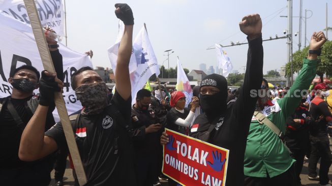 Sejumlah massa buruh yang tergabung dalam Konfederasi Serikat Pekerja Indonesia ( KSPI) mengelar aksi unjuk rasa di depan Gedung DPR, Jakarta, Rabu (29/7/2020). [Suara.com/Angga Budhiyanto]