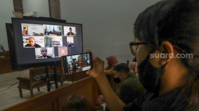 Awak media mengambil gambar Presenter Roy Kiyoshi saat mengikuti sidang tuntutan dirinya secara virtual di Pengadilan Negeri Jakarta Selatan, Rabu (29/7). [Suara.com/Alfian Winanto]