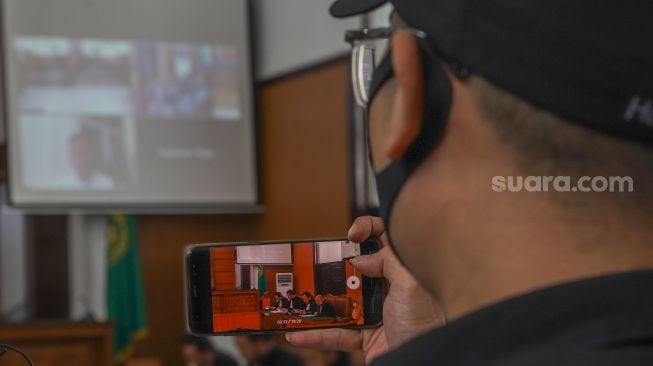 Awak media merekam jalannya sidang ekspesi Presenter Vicky Prasetyo yang digelar secara virtual di Pengadilan Negeri Jakarta Selatan, Rabu (29/7). [Suara.com/Alfian Winanto]