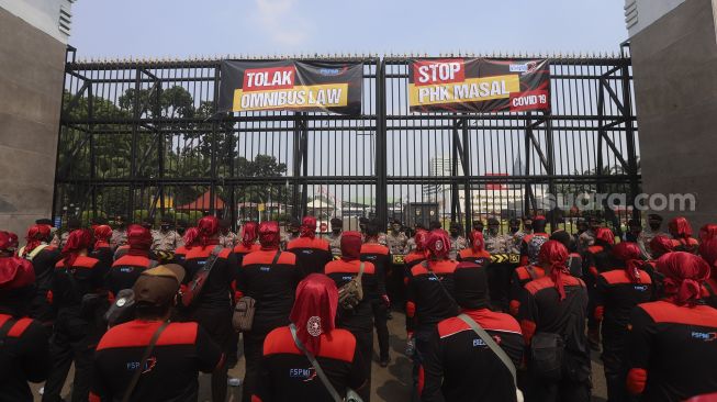 Sejumlah massa buruh yang tergabung dalam Konfederasi Serikat Pekerja Indonesia ( KSPI) mengelar aksi unjuk rasa di depan Gedung DPR, Jakarta, Rabu (29/7/2020). [Suara.com/Angga Budhiyanto]