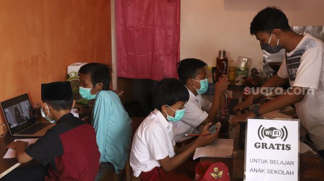 Empat orang siswa belajar secara online di Warkop Rizki, Pondok Aren, Tangerang Selatan, Banten, Rabu (29/7/2020). [Suara.com/Angga Budhiyanto]