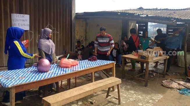 Zaimarni, Petugas Tagana Kota Batam, berkoordinasi dengan warga yang menjadi korban musibah kebakaran di posko darurat yang dibangun, Kamis (30/7/2020). [Suara.com/Bobi]