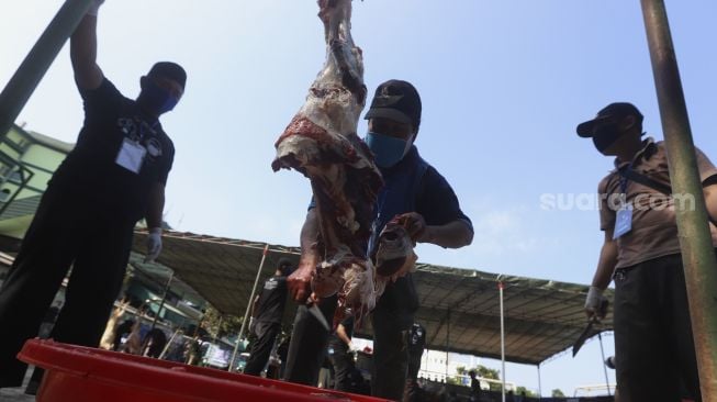 Petugas memotong daging kurban di lingkungan Masjid Al-Azhar, Jakarta, Jumat (31/7/2020). [Suara.com/Angga Budhiyanto]