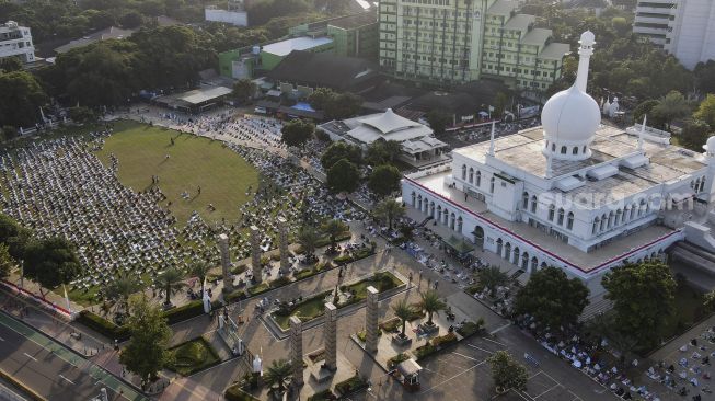 Foto udara sejumlah umat Muslim menunaikan ibadah Shalat Idul Adha 1441 H di lingkungan Masjid Al-Azhar, Jakarta, Jumat (31/7/2020). [Suara.com/Angga Budhiyanto]