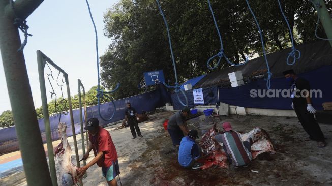 Petugas memotong daging kurban di lingkungan Masjid Al-Azhar, Jakarta, Jumat (31/7/2020). [Suara.com/Angga Budhiyanto]