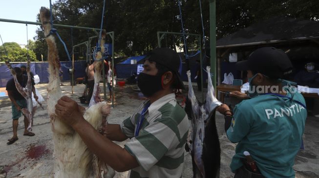 Petugas memotong daging kurban di lingkungan Masjid Al-Azhar, Jakarta, Jumat (31/7/2020). [Suara.com/Angga Budhiyanto]