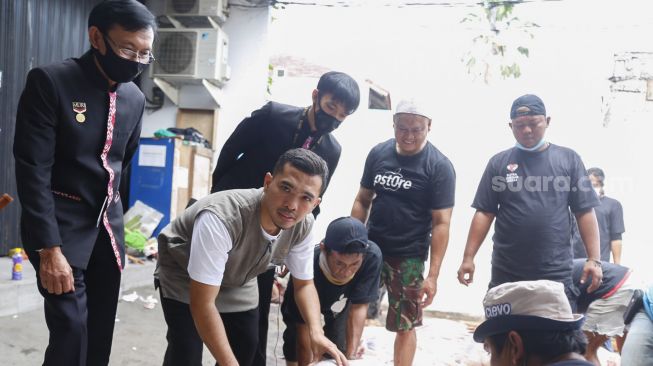 Pemilik PS Store Putra Siregar ikut memotong daging kurban saat pemecahan Rekor Muri pemotongan sebanyak 404 hewan kurban di Condet, Jakarta Timur, Jumat (31/7). [Suara.com/Alfian Winanto]