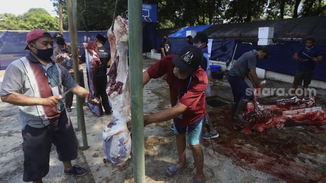 Petugas memotong daging kurban di lingkungan Masjid Al-Azhar, Jakarta, Jumat (31/7/2020). [Suara.com/Angga Budhiyanto]