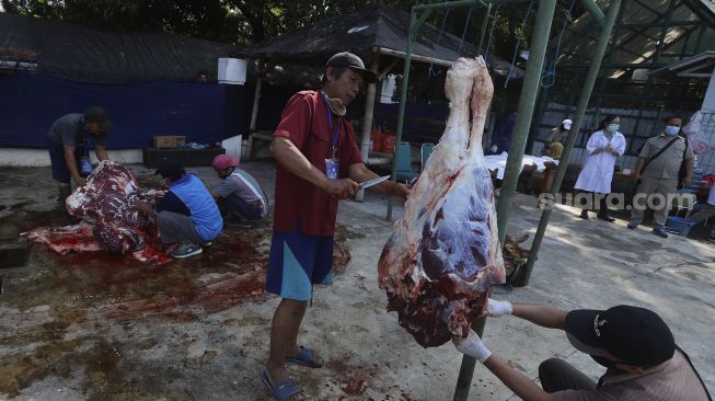 Petugas memotong daging kurban di lingkungan Masjid Al-Azhar, Jakarta, Jumat (31/7/2020). [Suara.com/Angga Budhiyanto]