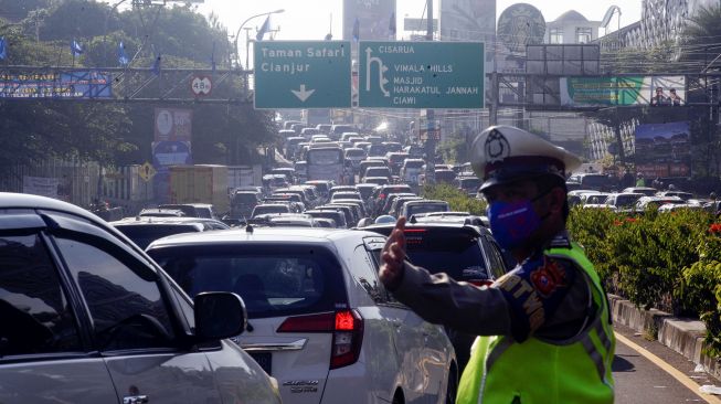 Petugas kepolisian mengatur kendaraan menuju jalur wisata Puncak, Gadog, Kabupaten Bogor, Jawa Barat, Sabtu (1/8/2020).  [ANTARA FOTO/Yulius Satria Wijaya]