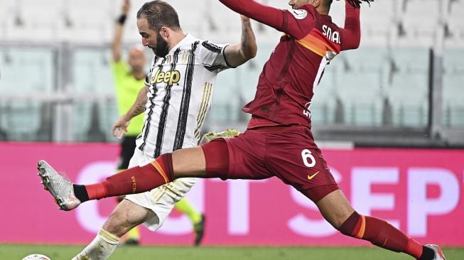 Pemain depan Juventus Gonzalo Higuain (kiri) berebut bola dengan bek Roma AS Chris Smalling saat pertandingan sepak bola Serie A Italia Juventus melawan AS Roma di stadion Allianz, Turin, Sabtu (1/8/2020). [Isabella Bonotto / AFP]