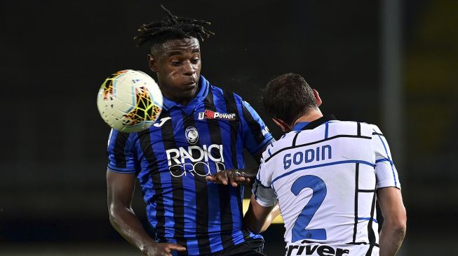 Pemain depan Atalanta Duvan Zapata (kiri) berebut bola dengan pemain belakang Inter Milan Diego Godin saat pertandingan sepak bola Serie A Italia Atalanta melawan Inter di stadion Atleti Azzurri d'Italia, Bergamopada, Sabtu (1/8/2020). [Miguel Medina/ AFP]