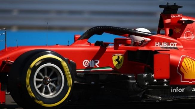 Pembalap Ferrari Sebastian Vettel melaju saat sesi latihan di trek Silverstone menjelang balapan F1 GP Inggris. Bryn LENNON / POOL / AFP