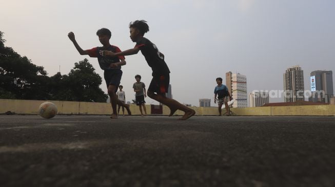 Sejumlah anak bermain sepakbola di rooftop Pasar Jaya Mampang, Jakarta, Minggu (2/8/2020). [Suara.com/Angga Budhiyanto]