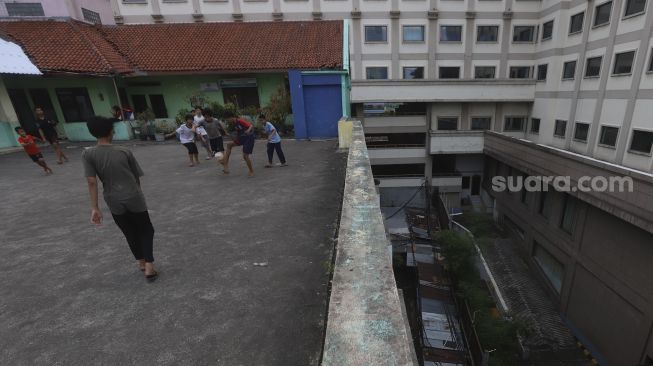 Sejumlah anak bermain sepakbola di rooftop Pasar Jaya Mampang, Jakarta, Minggu (2/8/2020). [Suara.com/Angga Budhiyanto]