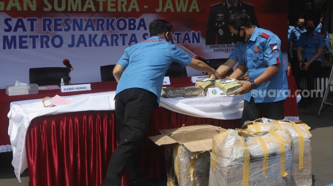 Anggota Ditresnarkoba Polres Metro Jakarta Selatan menyiapkan barang bukti narkoba saat menggelar konferensi pers kasus narkoba jaringan lintas Sumatera-Jawa di halaman Polres Metro Jakarta Selatan, Senin (3/8/2020). [Suara.com/Angga Budhiyanto]