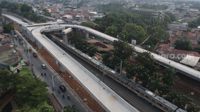 Foto udara sejumlah kendaraan melintas di samping proyek jalan layang (Flyover) tapal kuda di kawasan Lenteng Agung, Jakarta, Senin (3/8/2020). [Suara.com/Angga Budhiyanto]