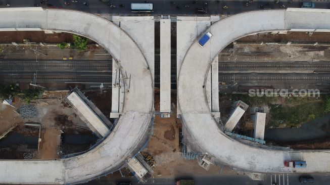 Foto udara sejumlah kendaraan melintas di samping proyek jalan layang (Flyover) tapal kuda di kawasan Lenteng Agung, Jakarta, Senin (3/8/2020). [Suara.com/Angga Budhiyanto]