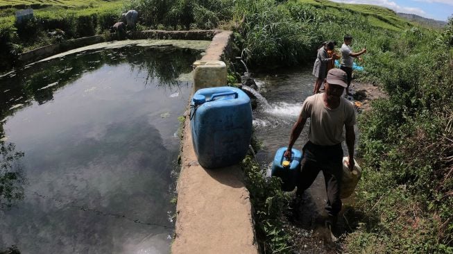 Seorang warga Sungai Jambu membawa jeriken berisi air yang diambil dari sumber mata air di kaki Gunung Kerinci, Kayu Aro Barat, Kerinci, Jambi, Minggu (2/8/2020).  [ANTARA FOTO/Wahdi Septiawan]