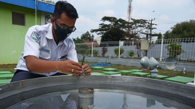 Petugas Badan Meteorologi, Klimatologi dan Geofisika (BMKG) memeriksa alat ukur penguapan (Open Pan Evaporimeter) di Laboratorium BMKG Serang, Banten, Senin (3/8/2020). [ANTARA FOTO/Asep Fathulrahman]
