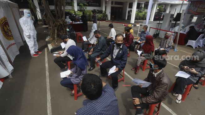 Sejumlah pegawai KPU dan Wartawan mengantre untuk mengikuti tes usap (swab test) secara massal di Gedung Komisi Pemilihan Umum Republik Indonesia ((KPU RI) Jakarta, Selasa (4/8/2020). [Suara.com/Angga Budhiyanto]