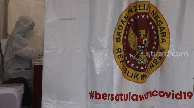 Petugas kesehatan mendata pegawai KPU dan Wartawan yang mengikuti tes usap (swab test) secara massal di Gedung Komisi Pemilihan Umum Republik Indonesia ((KPU RI) Jakarta, Selasa (4/8/2020). [Suara.com/Angga Budhiyanto]