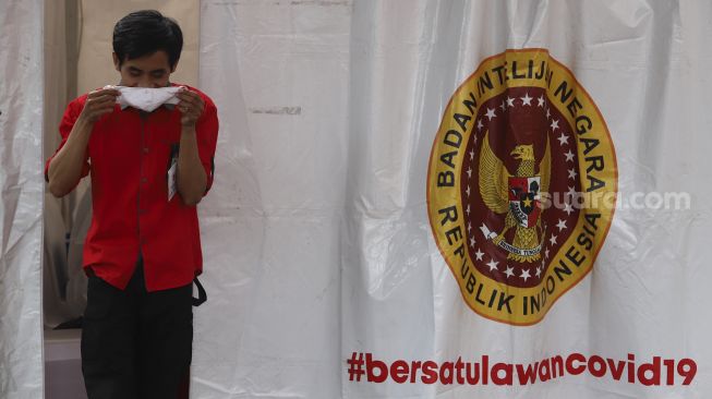 Seorang Wartawan keluar dari bilik tes usai mengikuti tes usap (swab test) secara massal di Gedung Komisi Pemilihan Umum Republik Indonesia ((KPU RI) Jakarta, Selasa (4/8/2020). [Suara.com/Angga Budhiyanto]