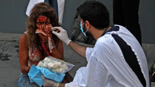 Petugas medis membantu warga yang terluka di lokasi ledakan di pelabuhan kota di Beirut, Lebanon, Selasa (4/8).  [Foto/AFP]