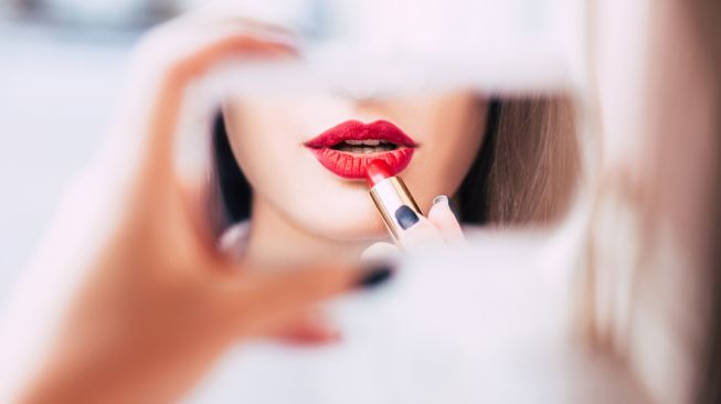 Ilustrasi menggunakan lipstik merah. (Shutterstock)