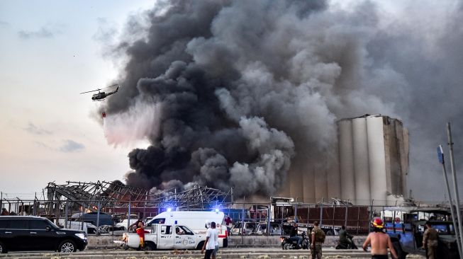 Sebuah helikopter memadamkan api di lokasi ledakan di pelabuhan kota di Beirut, Lebanon, Selasa (4/8).  [Foto/AFP]