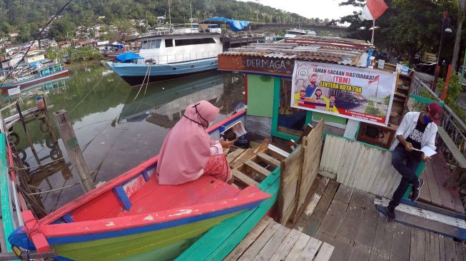 Sejumlah warga membaca buku di Taman Bacaan Masyarakat (TBM) Lentera Kota Tua, di tepian sungai Batang Arau, Padang, Sumatera Barat, Rabu (5/8/2020). [ANTARA FOTO/Iggoy el Fitra]